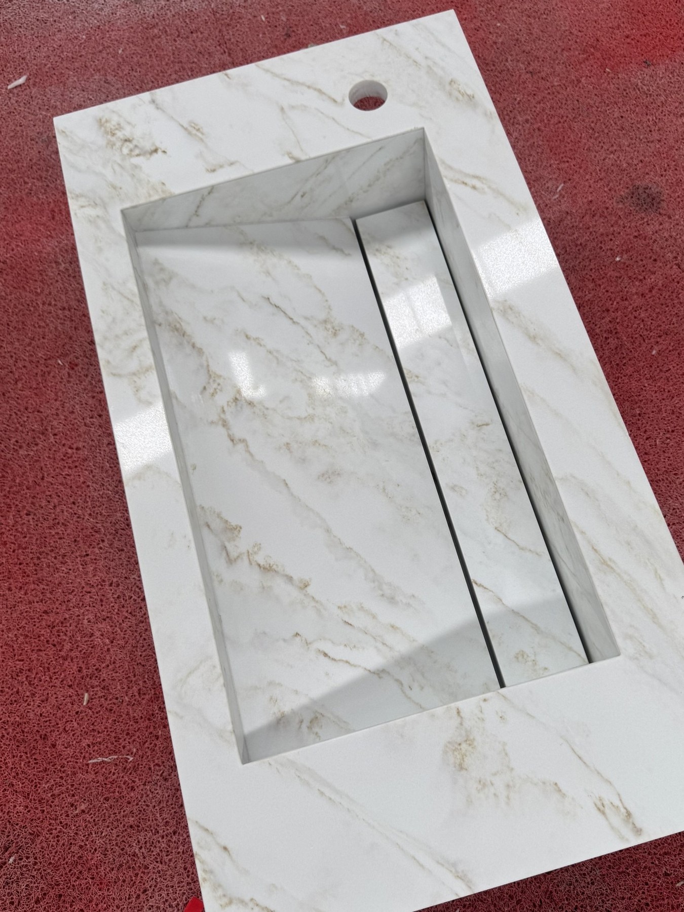 Overhead view of a glass stone vanity top showing the integrated sink and linear slot drain